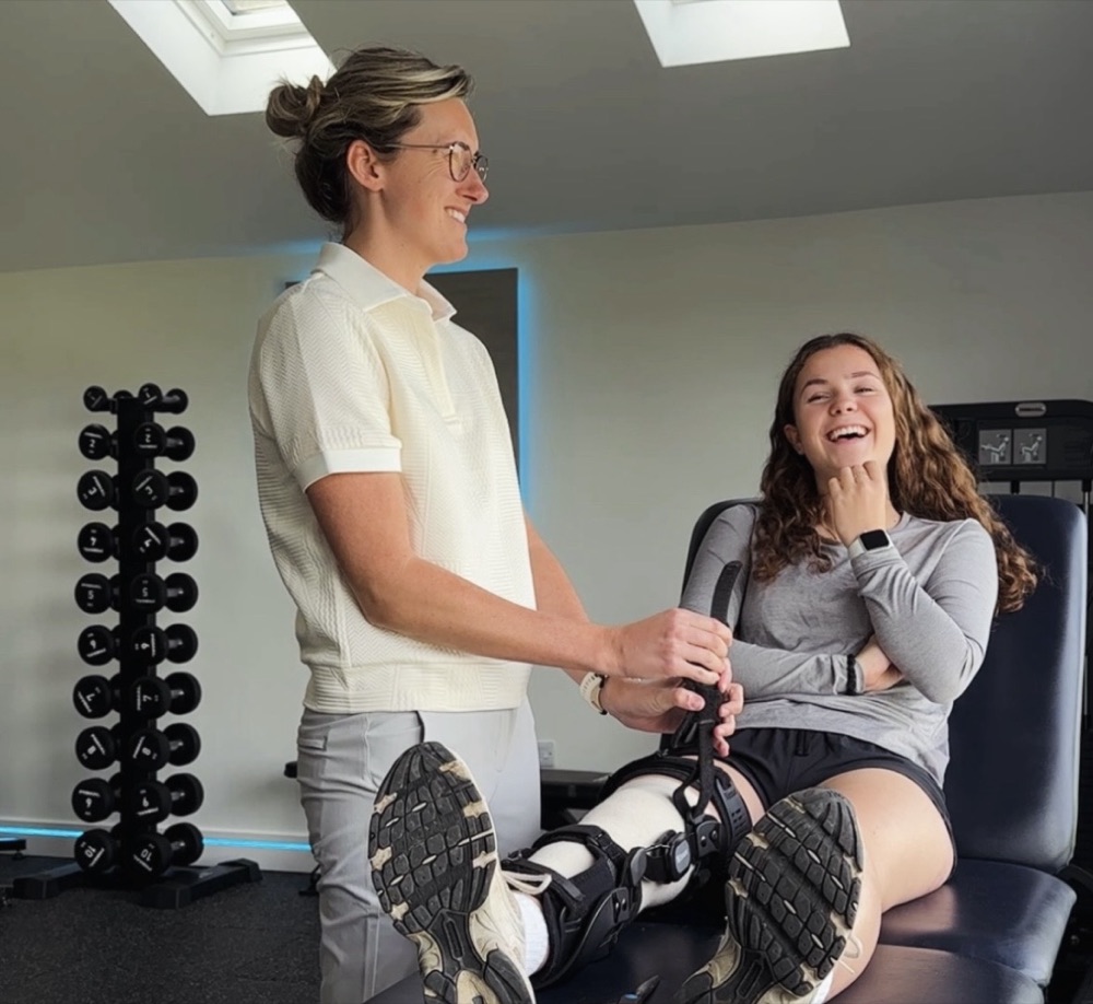 Tilly fitting a knee brace with a laughing patient